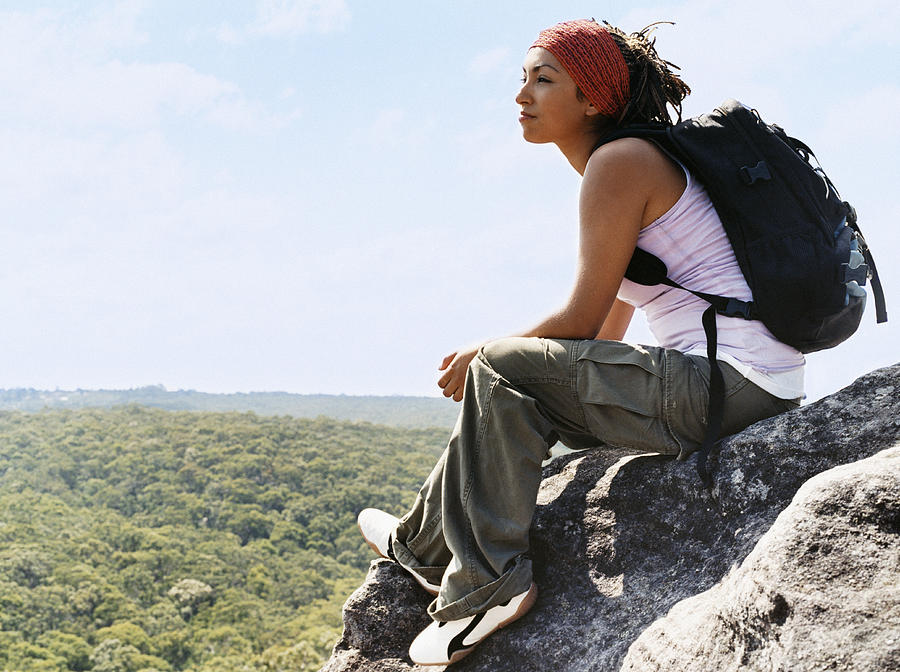 Woman Sitting on Rock Looking at View Photograph by Digital Vision.