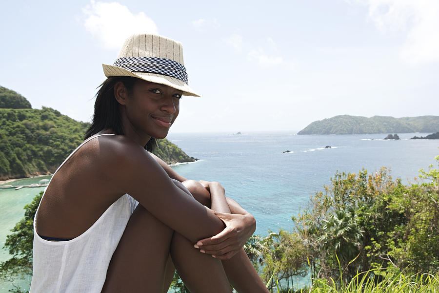 Woman sitting overlooking Caribbean Ocean bay Photograph by Ralf Nau