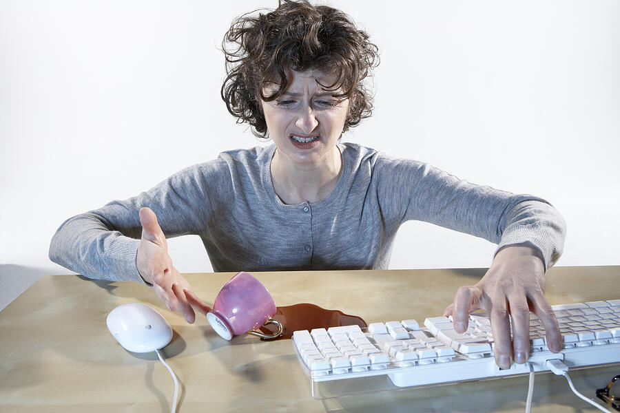 Woman spilling coffe near computer keyboard Photograph by Vincent Besnault