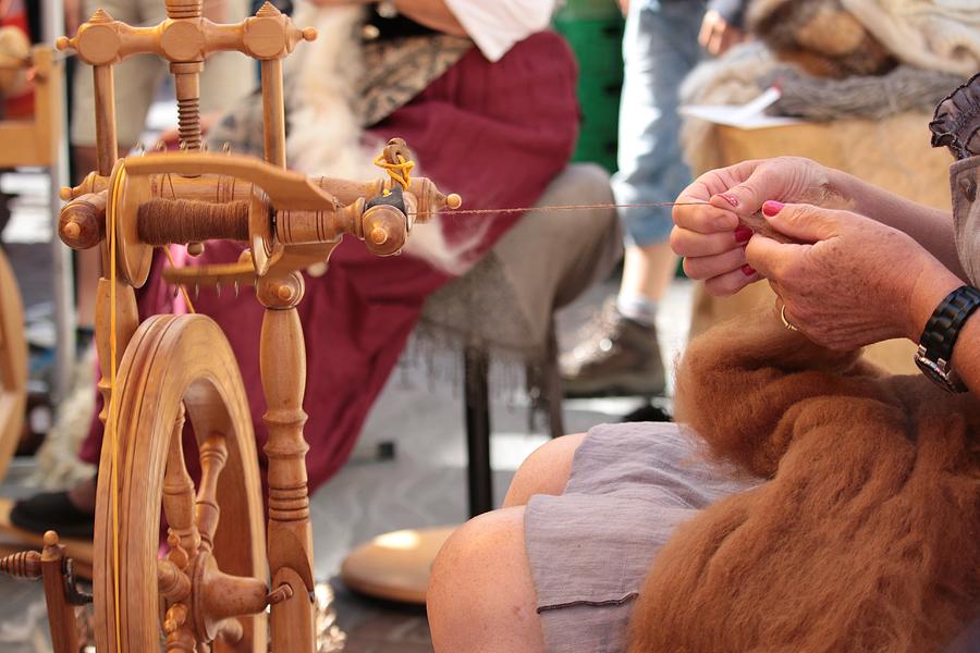 Woman spinning wheel to make yarn Photograph by German Osorio / FOAP