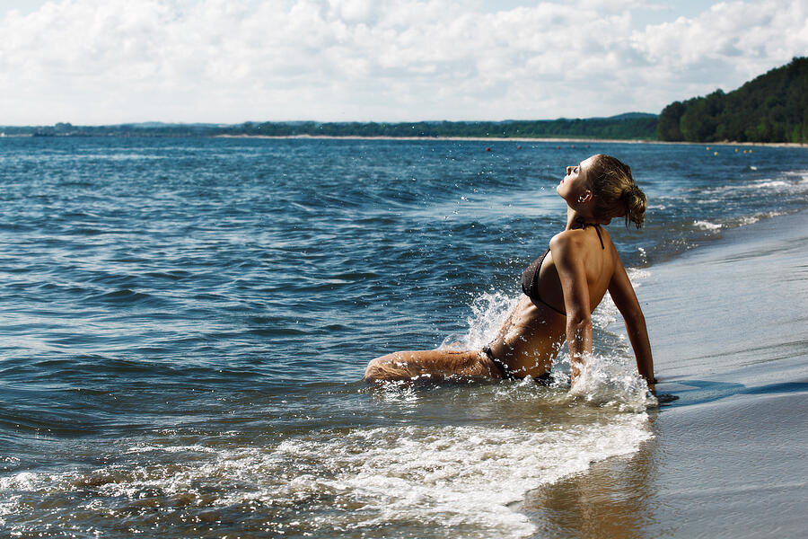 Woman splashing in sea Photograph by Fotek