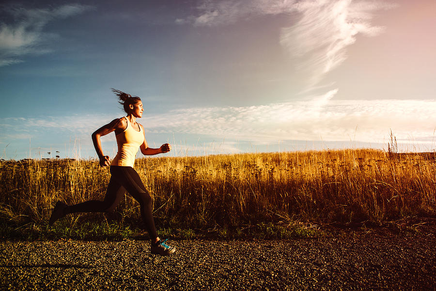 Woman Sprinting on Beautiful Sunset Road Photograph by RyanJLane