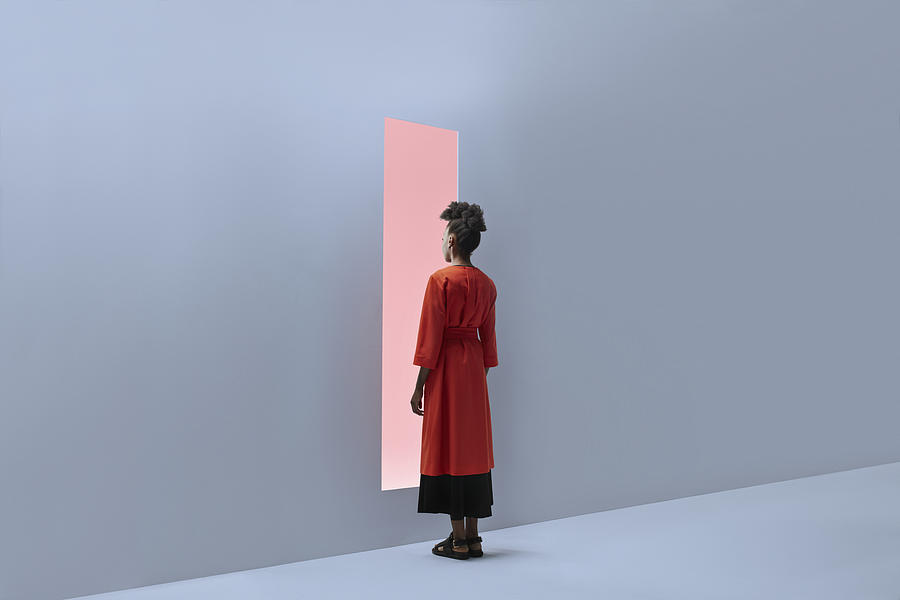 Woman standing in front of rectangular opening in coloured wall Photograph by Klaus Vedfelt