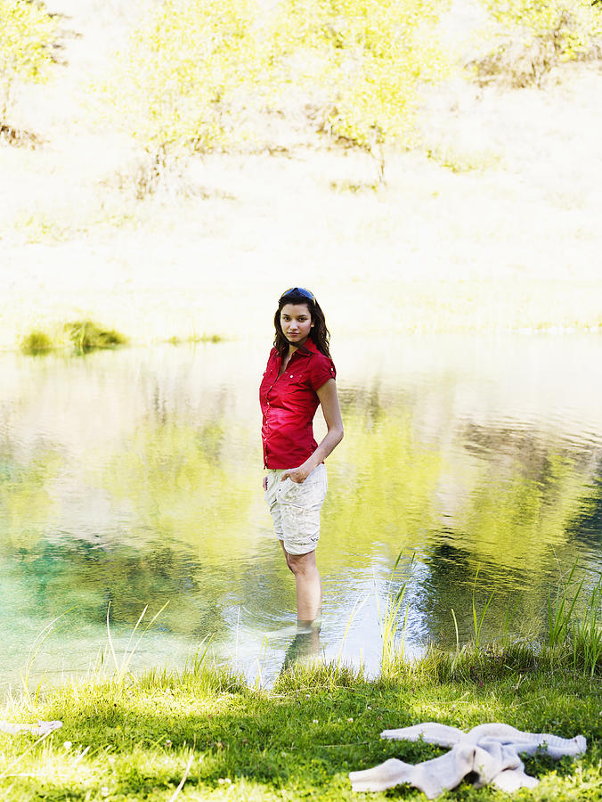 Woman standing in pond Photograph by Thomas Barwick