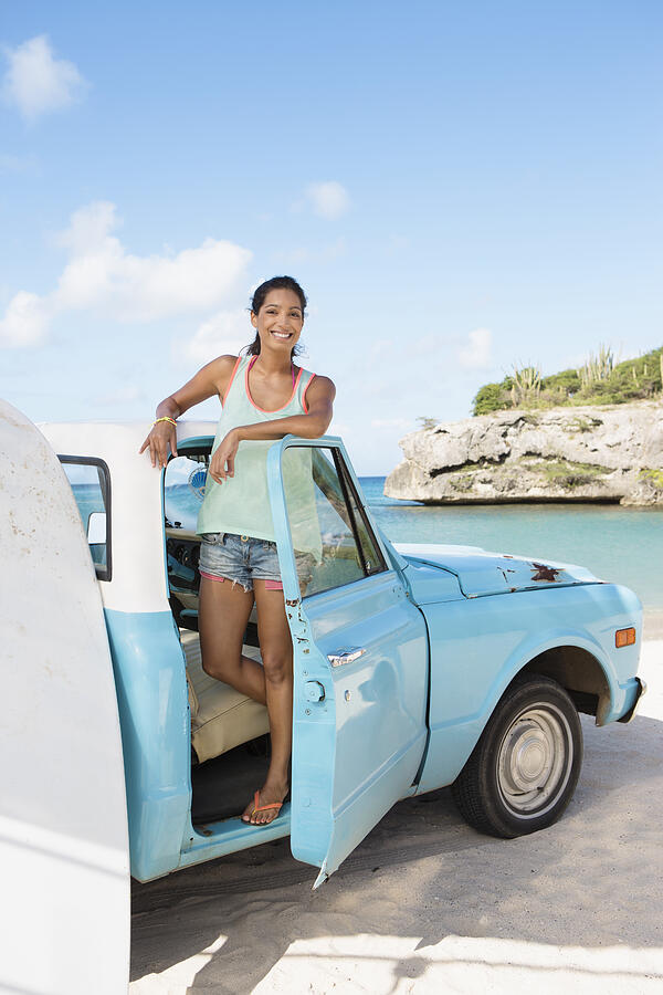 Woman standing in truck and smiling Photograph by Felix Wirth