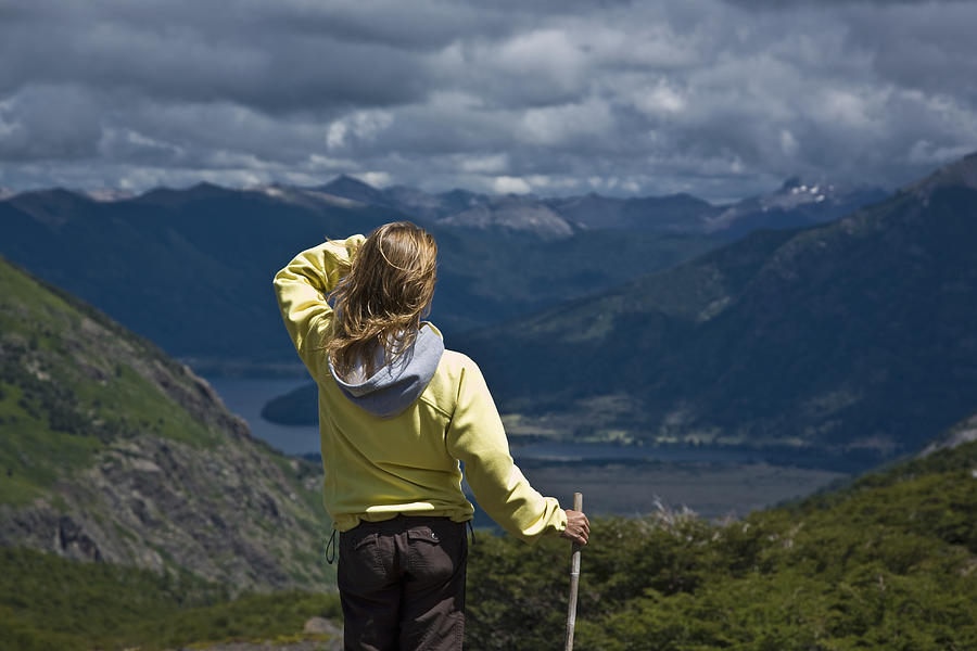 Woman standing on mountain, looking over valley, rear view Photograph by Picturegarden