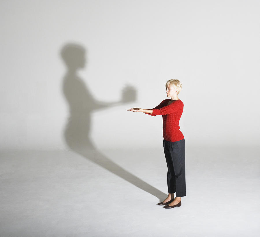 Woman standing with her shadow giving her a gift Photograph by Martin Barraud