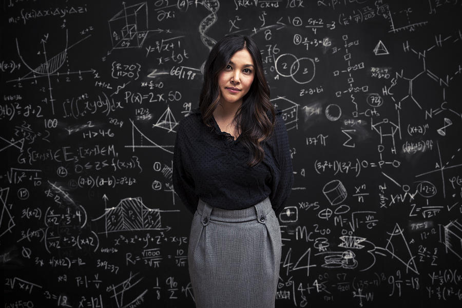 Woman stands calm in front of math chalkboard Photograph by Justin Lewis