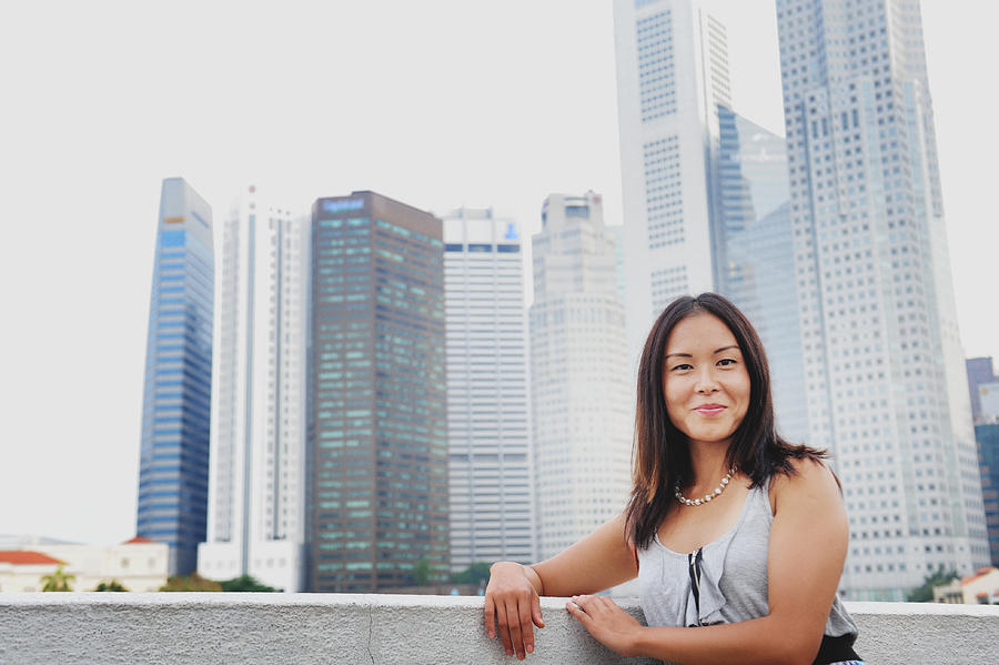 Woman stands in front of Singapore skyline Photograph by Carlina Teteris