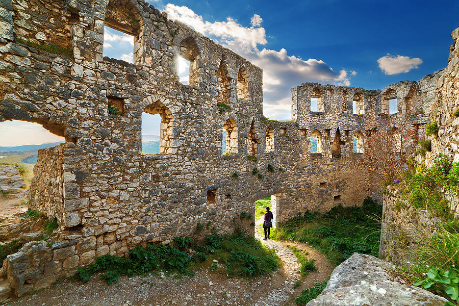 Woman stands under old ruins, Pocitelj, Bosnia Photograph by Anna Gorin