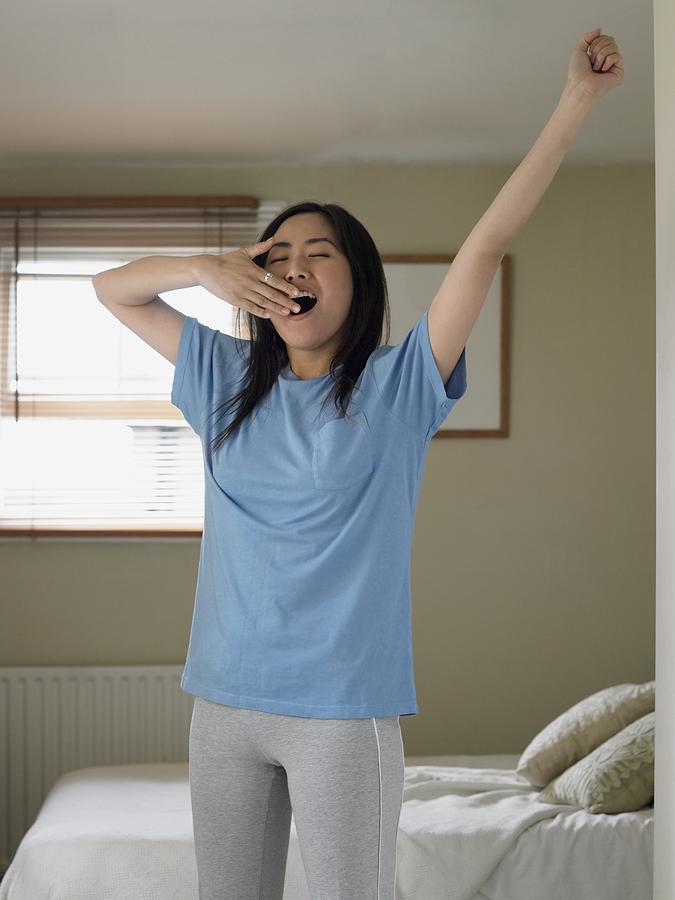 Woman stretching and yawning Photograph by Image Source