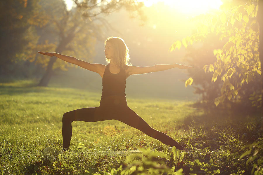 Woman stretching in nature Photograph by GoodLifeStudio