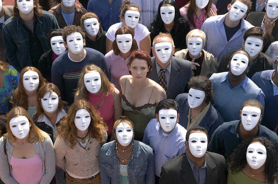 Woman Surrounded by a Crowd of People Wearing Masks Photograph by Digital Vision.