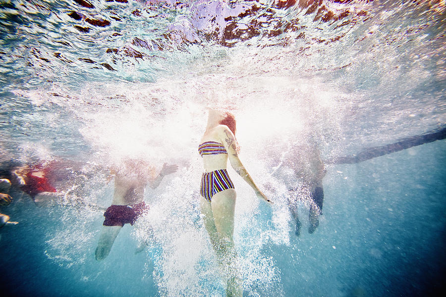 Woman swimming to surface of pool underwater view Photograph by Thomas Barwick