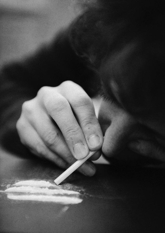 Woman taking drugs, close-up, b&w Photograph by Laurent Hamels