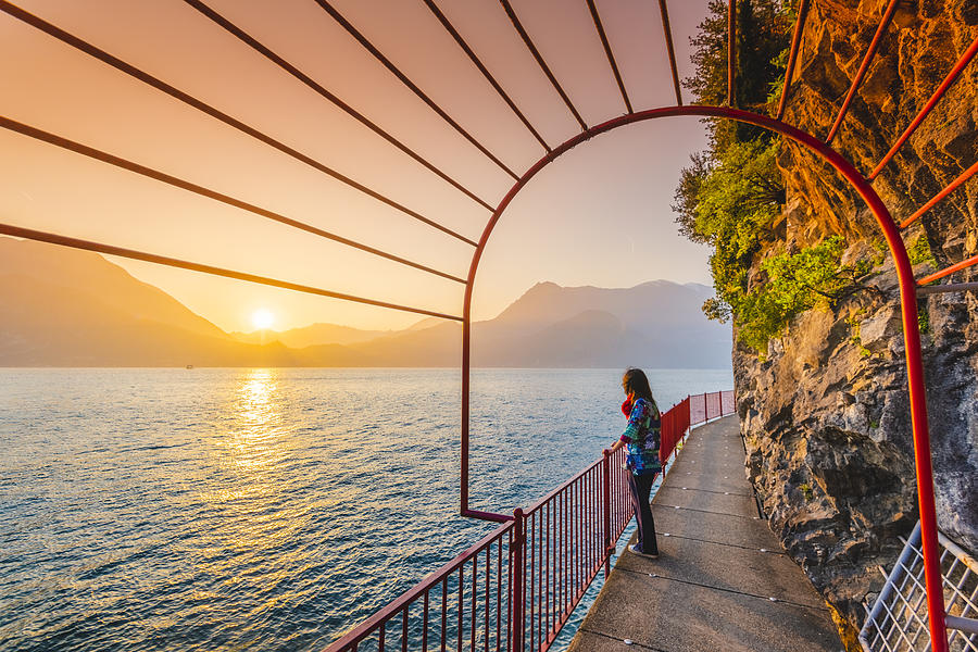 Woman tourist enjoying sunset in Varenna, lake Como, Italy Photograph by © Marco Bottigelli