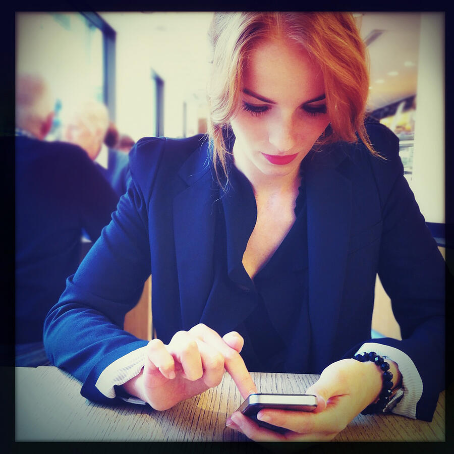 Woman using a smart phone Photograph by Ixefra