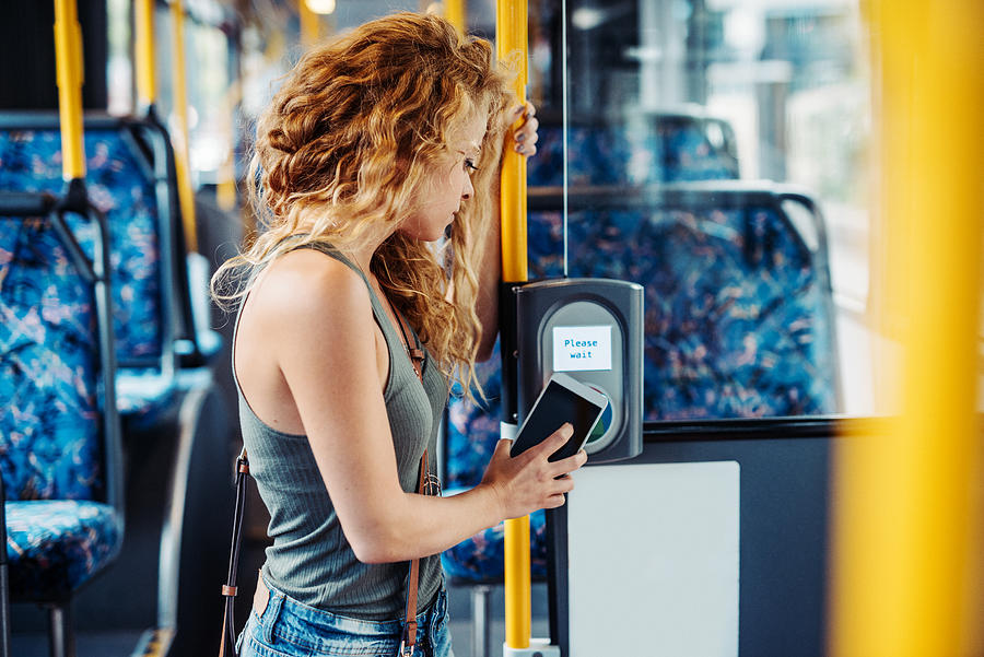 Woman using contactless card payment for public transport Photograph by Drazen_