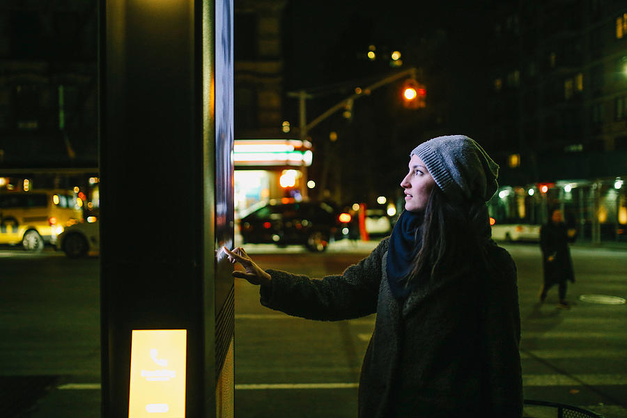 Woman using touch screen city display Photograph by Lechatnoir