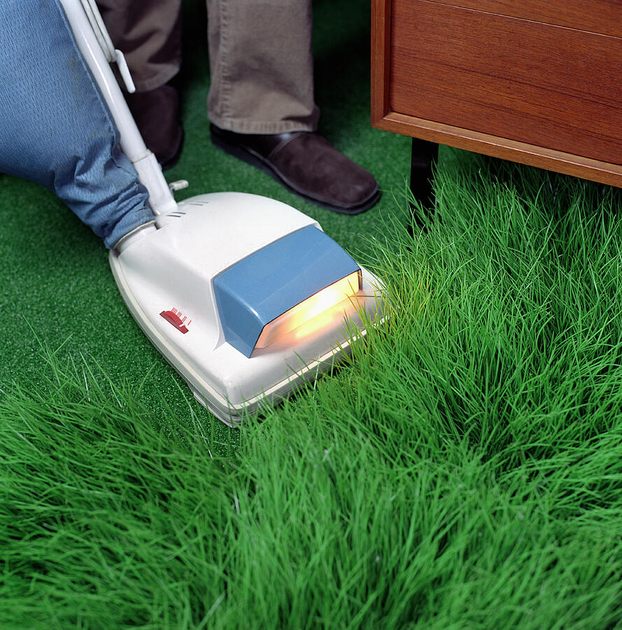 Woman vacuuming artificial grass, low section Photograph by Erik Dreyer