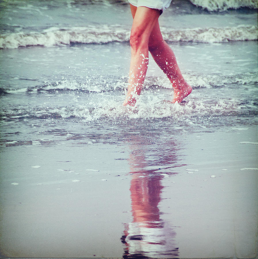 Woman walking in water at seashore Photograph by Julia Davila-Lampe