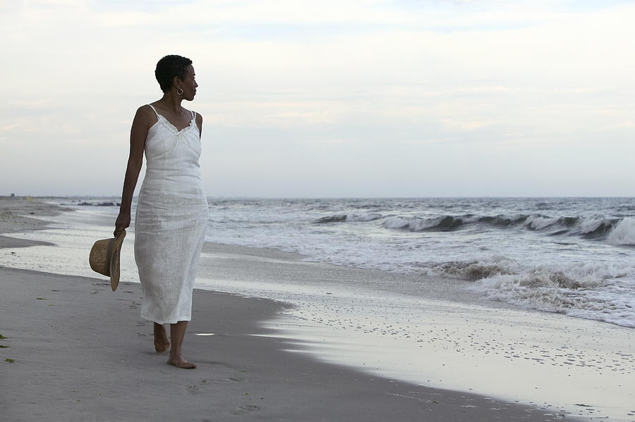 Woman walking on beach Photograph by Comstock Images