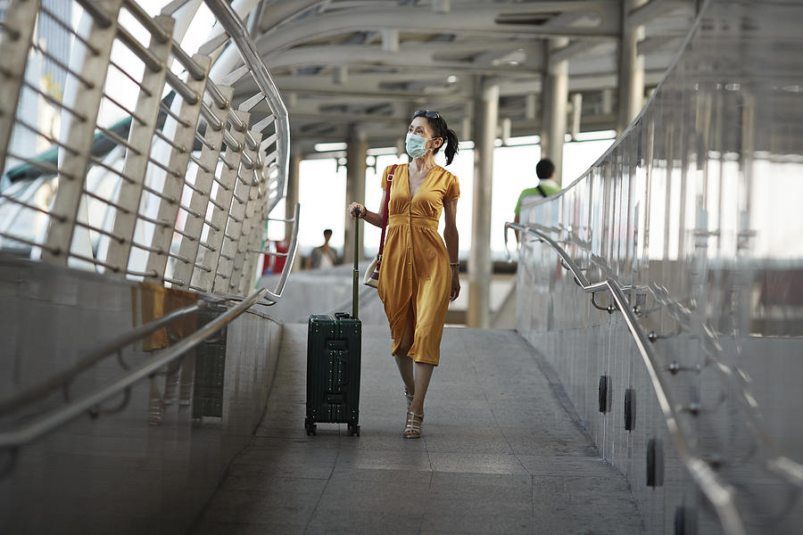 Woman walking with luggage at railroad station Photograph by Klaus Vedfelt