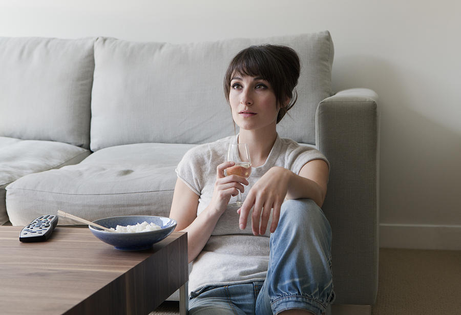 Woman watching television with dinner Photograph by Clarissa Leahy