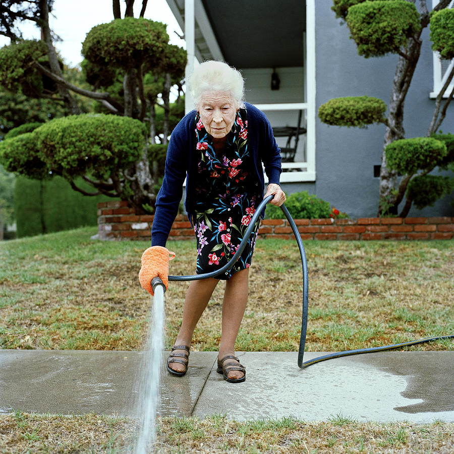 Woman watering her front lawn Photograph by Tom M Johnson