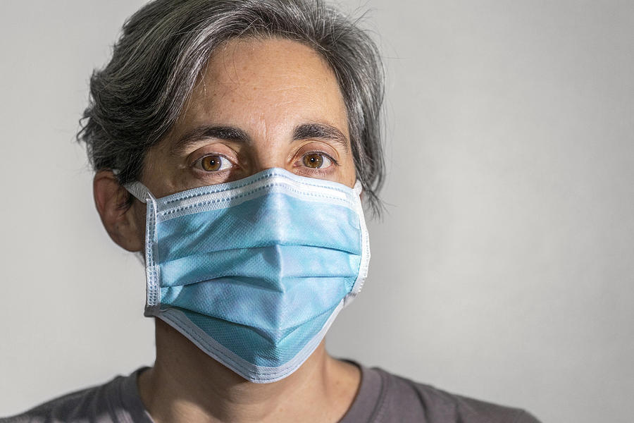 Woman wearing a surgical mask, protective face mask against infectious diseases like coronavirus and influenza Photograph by Andrew Merry
