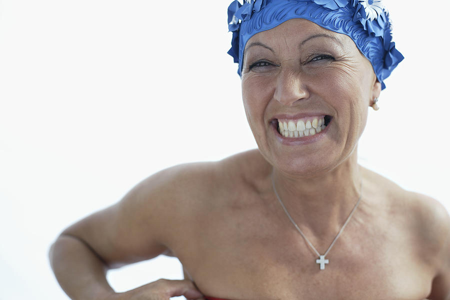 Woman wearing bathing cap smiling Photograph by Floresco Productions