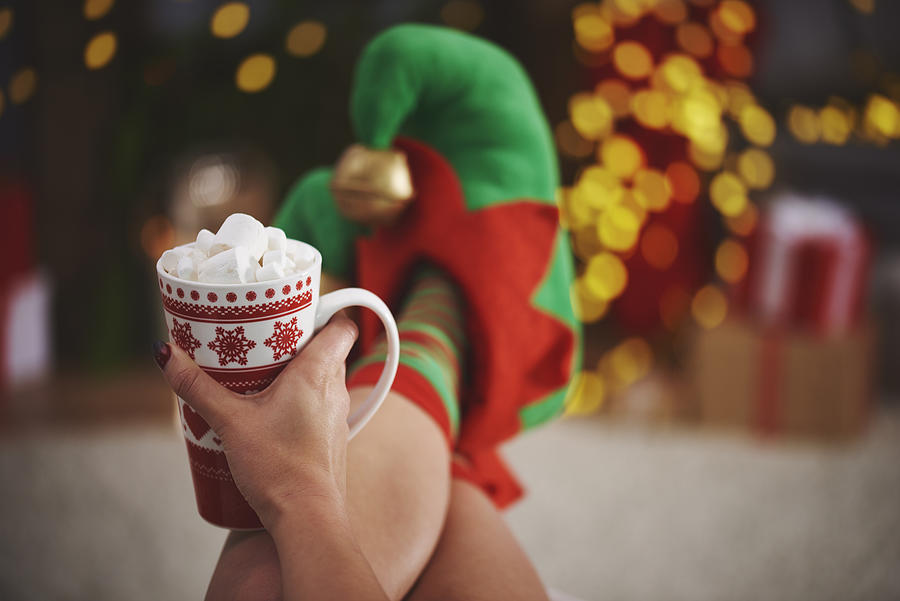 Woman wearing elf slippers holding hot chocolate Photograph by Gpointstudio