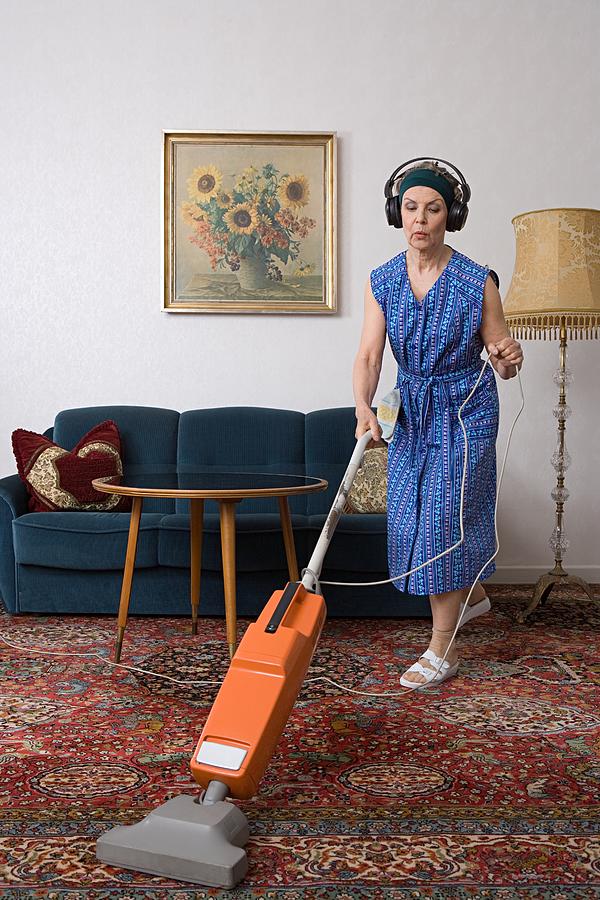 Woman wearing headphones and vacuuming Photograph by Image Source
