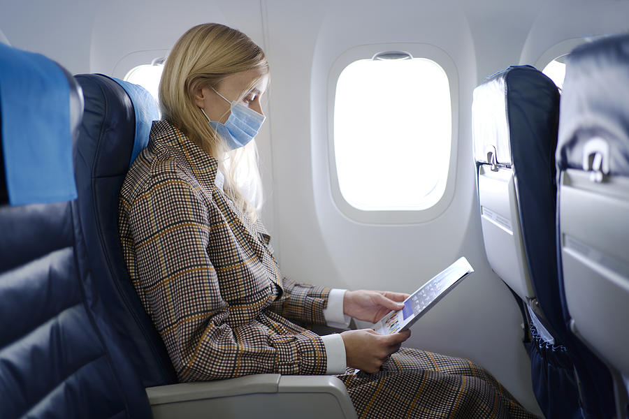 Woman wearing mask inside airplane Photograph by Andriy Onufriyenko