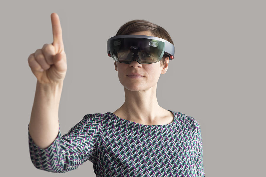 Woman wearing mixed reality smartglasses raising her hand Photograph by Westend61