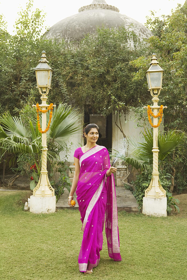 Woman wearing sari in garden, India Photograph by Jupiterimages