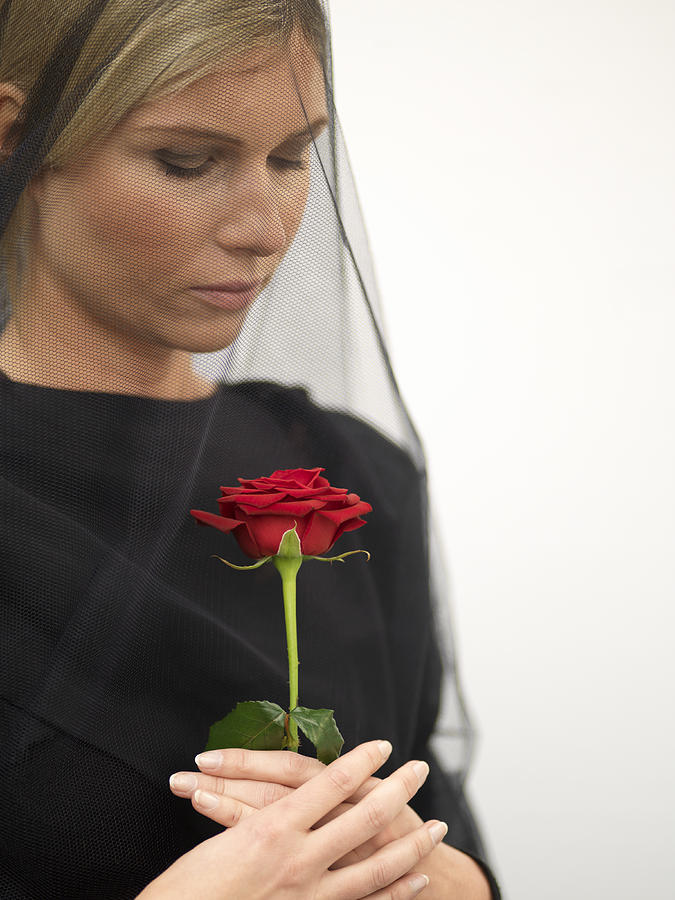 Woman wearing veil holding rose, close-up Photograph by Bob Thomas