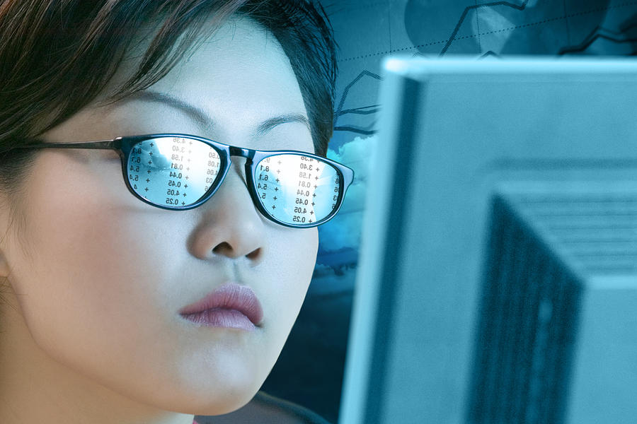 Woman with a reflection off a computer in her glasses Photograph by Comstock Images
