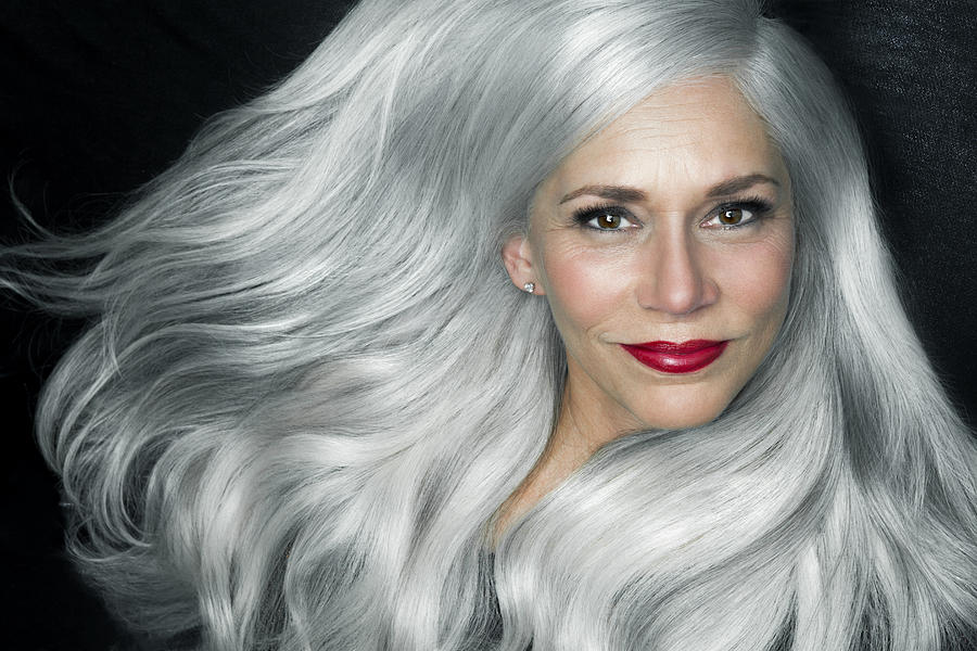 Woman with big, wavy, silver gray hair, portrait. Photograph by Andreas Kuehn