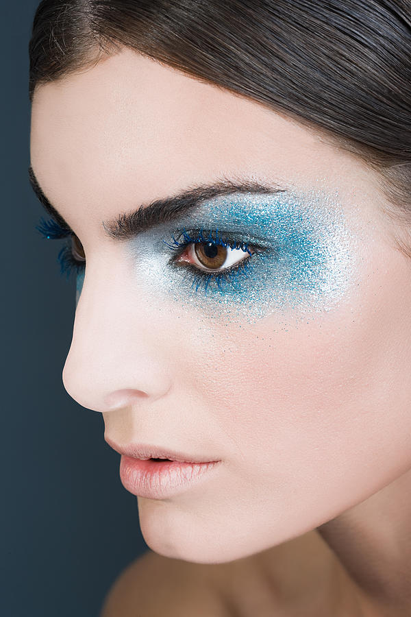 Woman with blue glitter eye makeup Photograph by Image Source