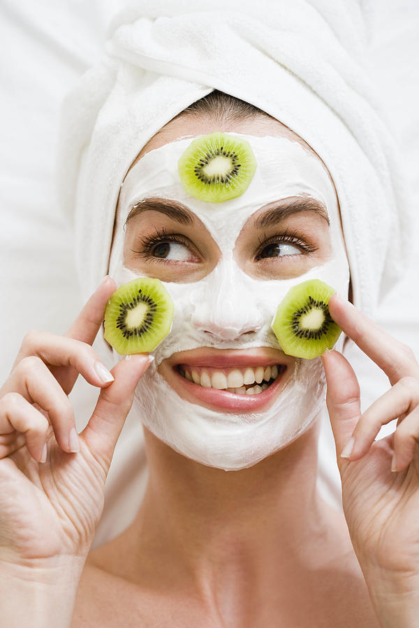 Woman with face mask and kiwi fruit Photograph by Brigitte Sporrer