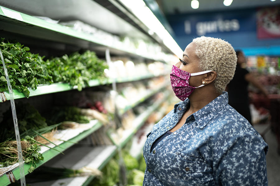 Woman with face mask shopping at supermarket Photograph by FG Trade