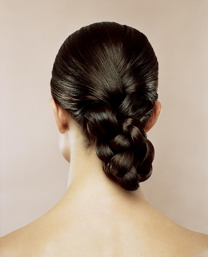 Woman with hair braided, rear view Photograph by Andreas Kuehn