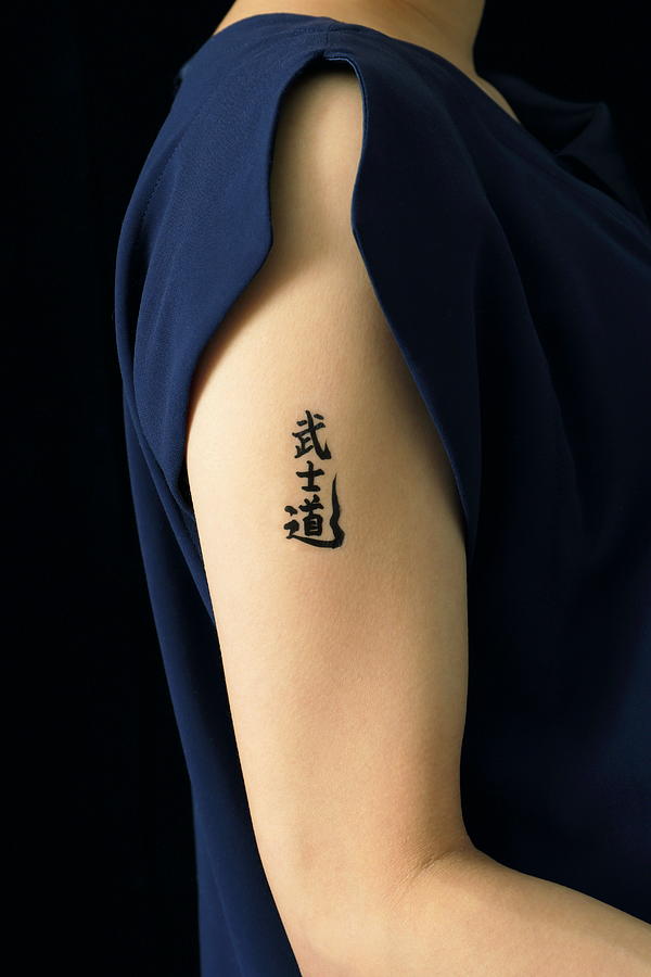 Woman with kanji tattoo seal on arm,close up Photograph by Sot