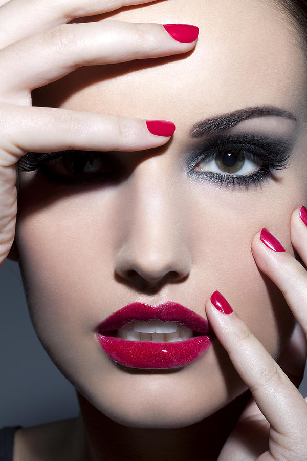 Woman with red lips and nails, close up. Photograph by Andreas Kuehn