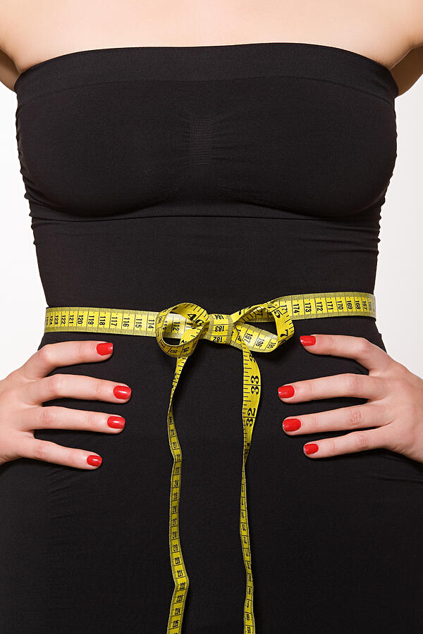 Woman with tape measure around her waist Photograph by Image Source
