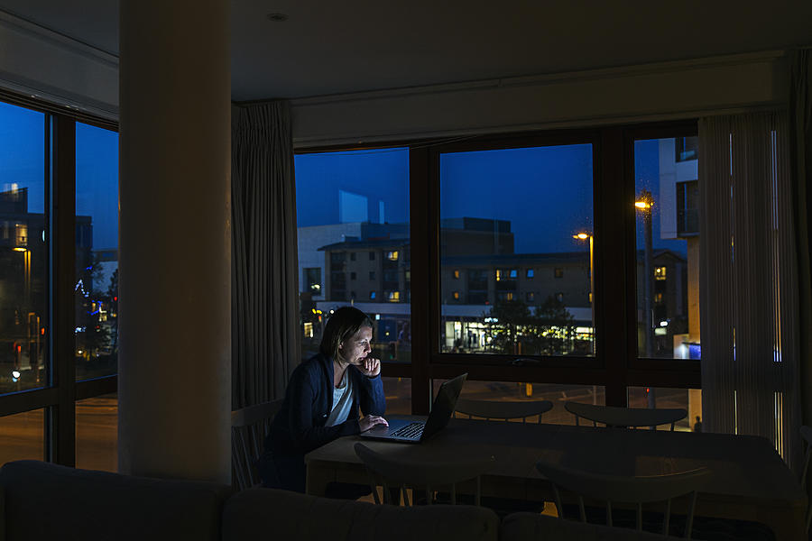 Woman working from home at night Photograph by Justin Paget