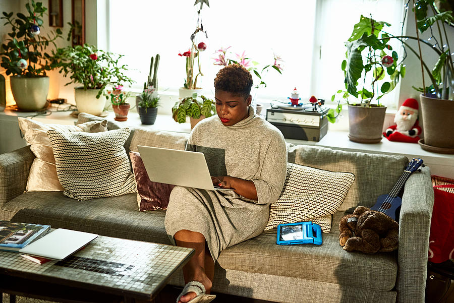 Woman working from home on sofa with laptop Photograph by 10000 Hours