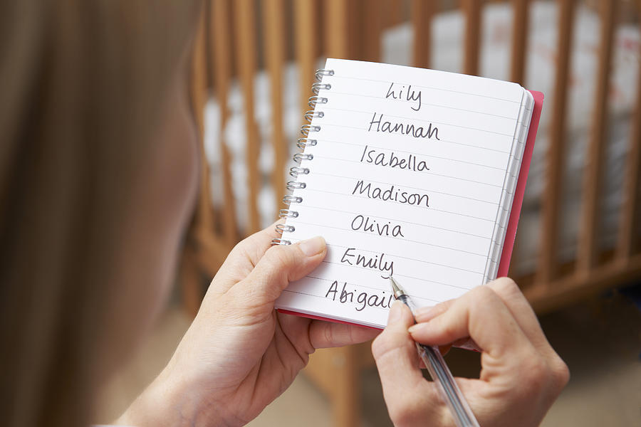 Woman Writing Possible Names For Baby Girl In Nursery Photograph by MachineHeadz