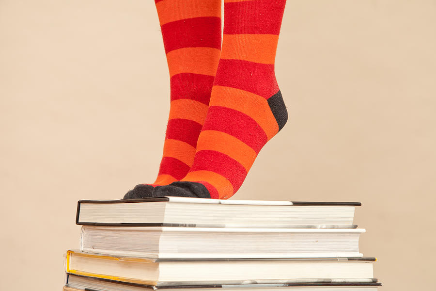 Womans Feet in stripy socks standing on stack of books Photograph by JamieB